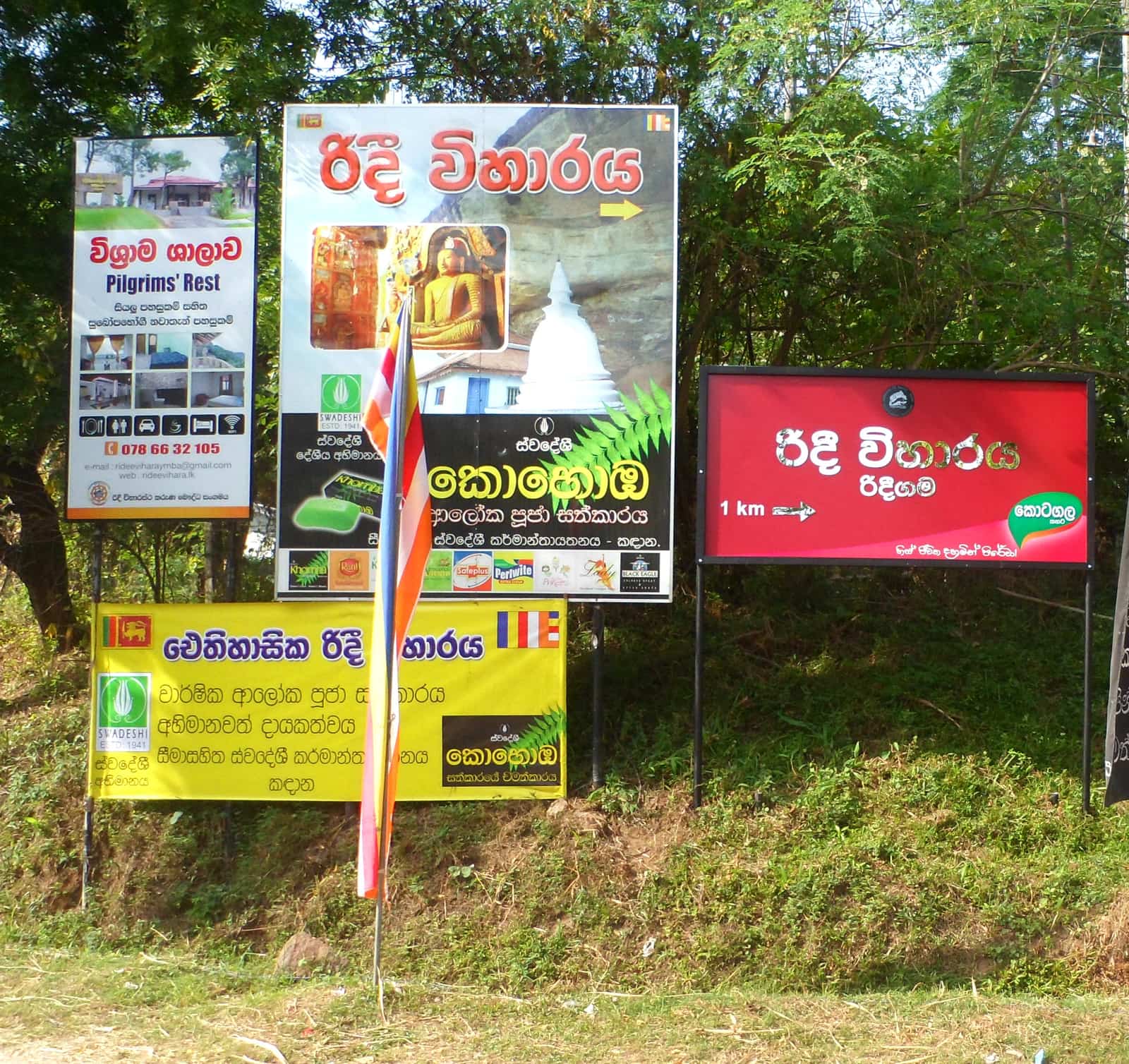 Roadside cluster of dealer and directional boards near Ridi Viharaya