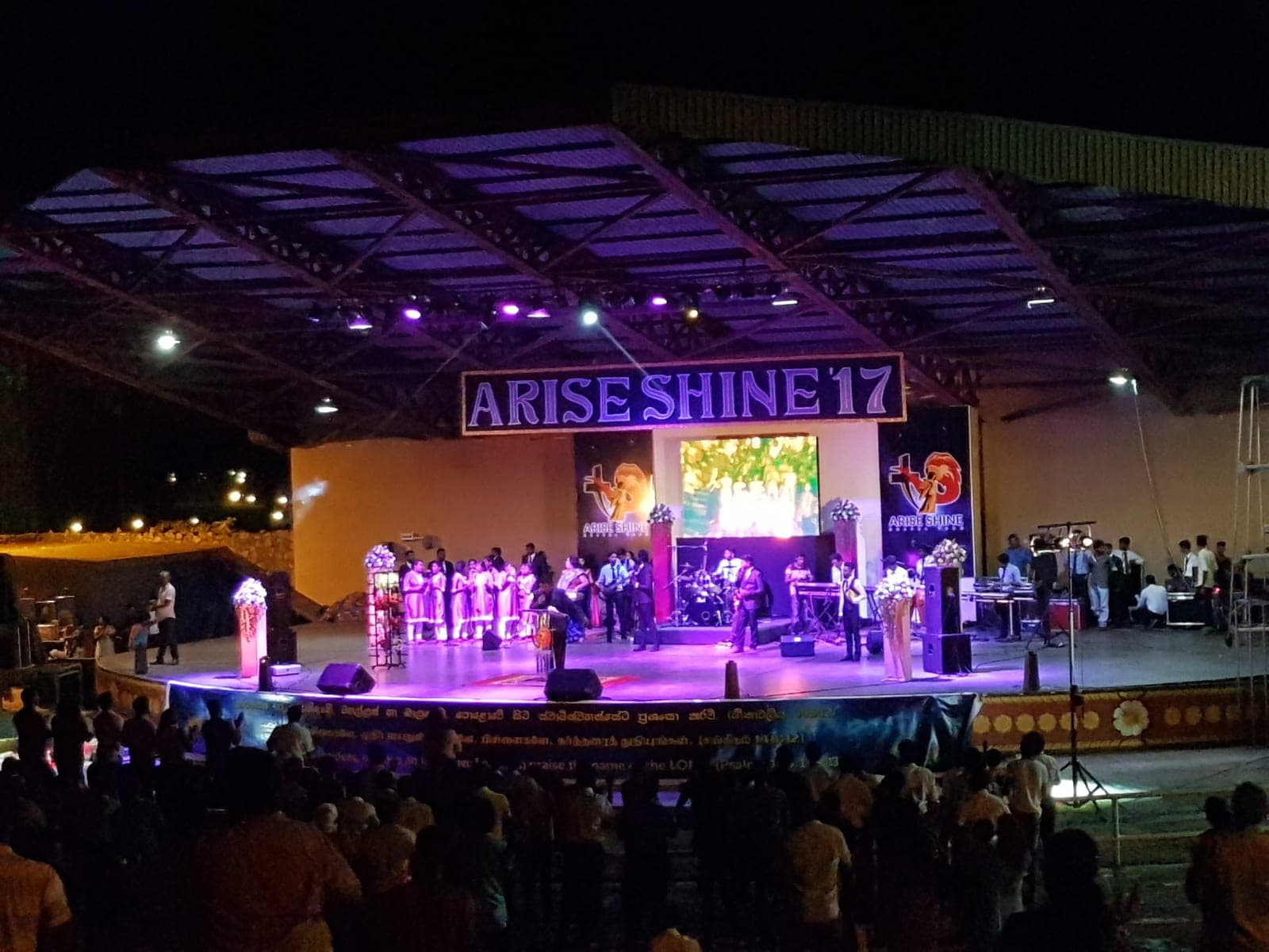 'Arise Shine' stage with performers under coloured lighting at night