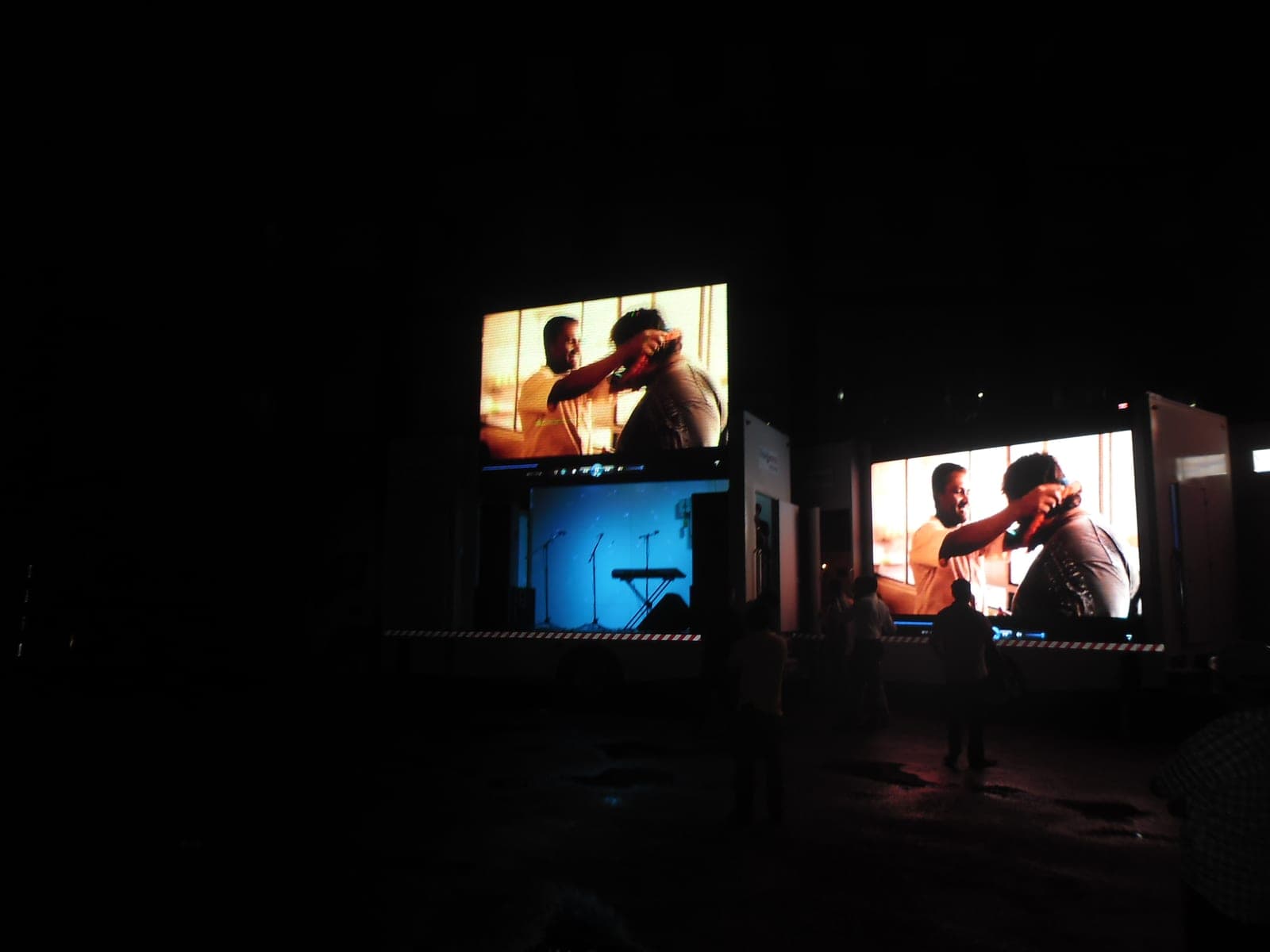 Two mobile LED advertising trucks screening content at night