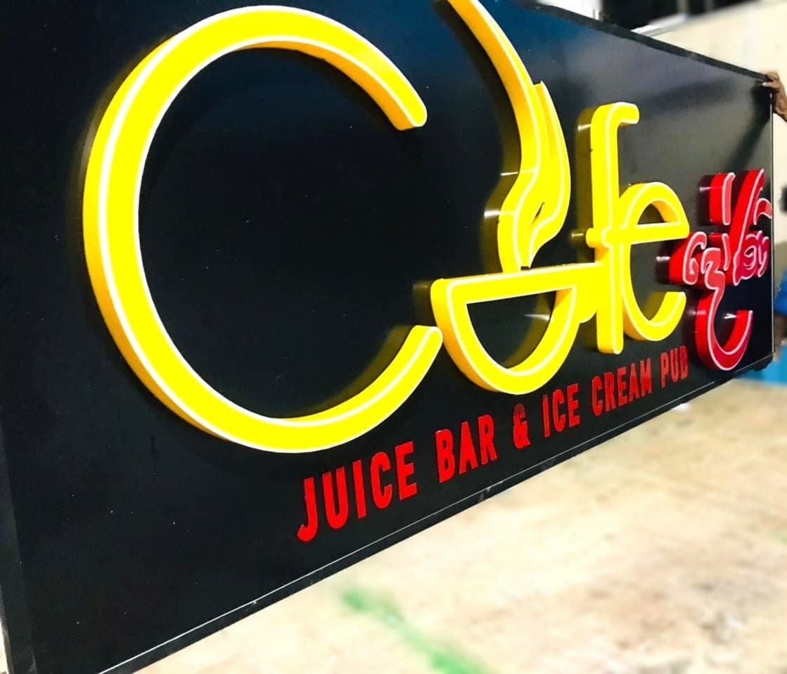 'Cafe – Juice Bar & Ice Cream' illuminated letters, lit at night
