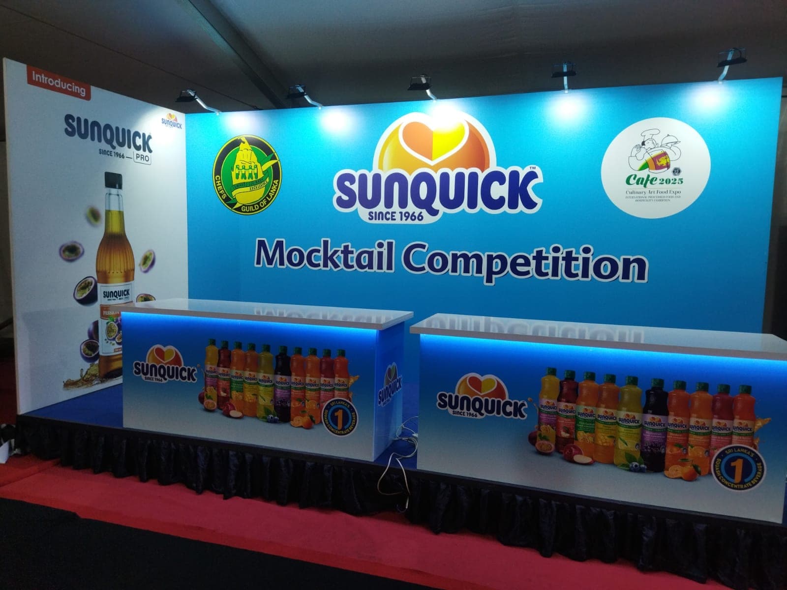 Sunquick Mocktail Competition exhibition stall with a blue backlit product bar
