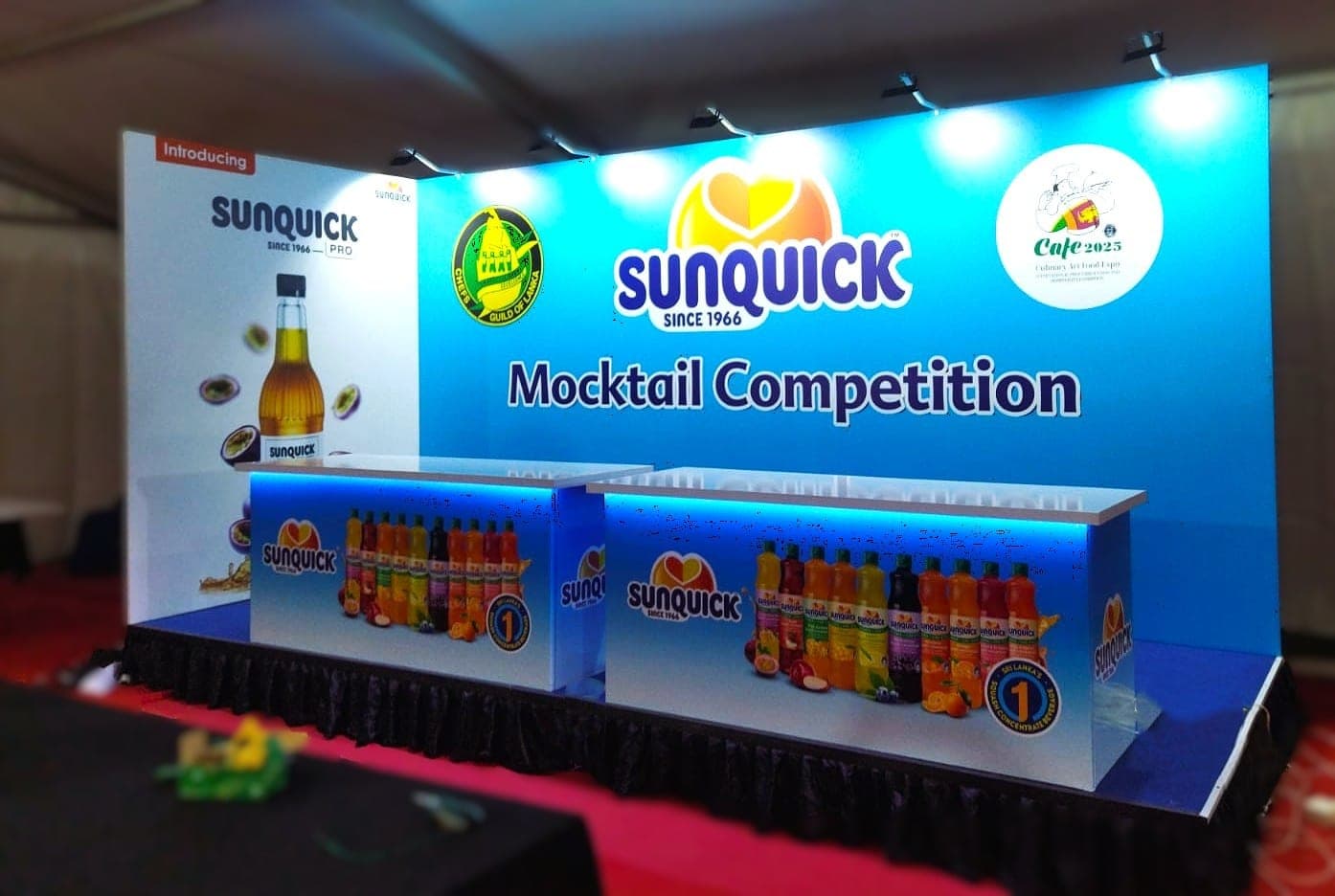 Sunquick Mocktail Competition booth with a lit product counter, wide view
