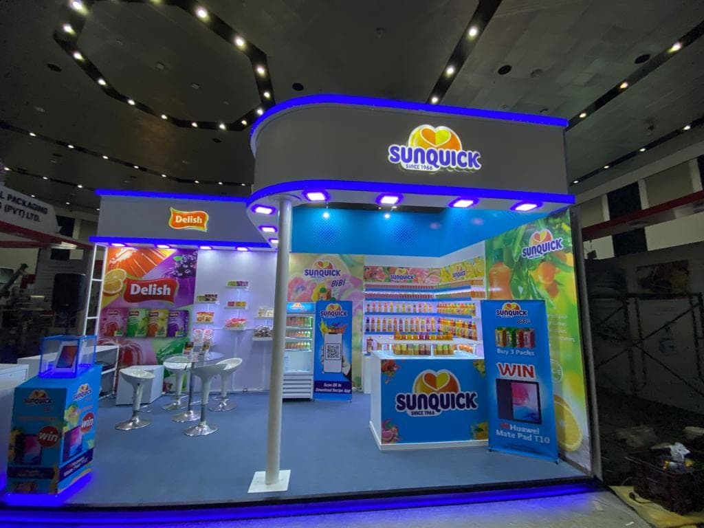 Delish and Sunquick exhibition stall, wide view under blue cove lighting