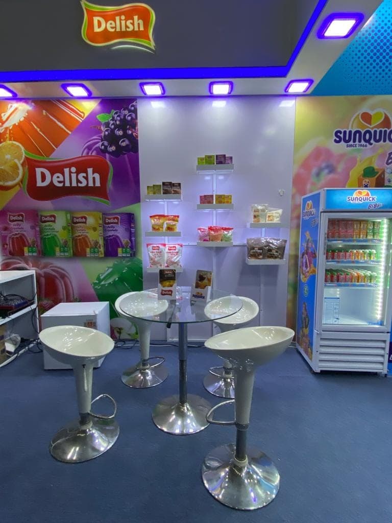 Inside the Delish and Sunquick stall with bar stools and a branded cooler