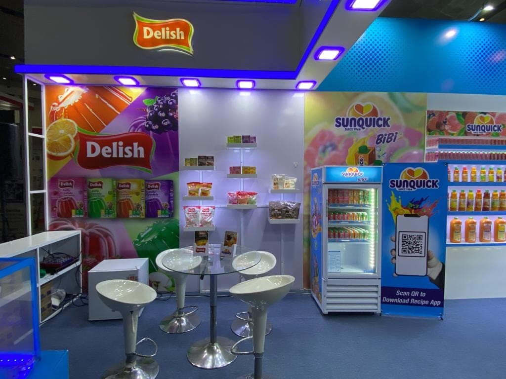 Delish and Sunquick stall interior with seating, cooler and lit product walls