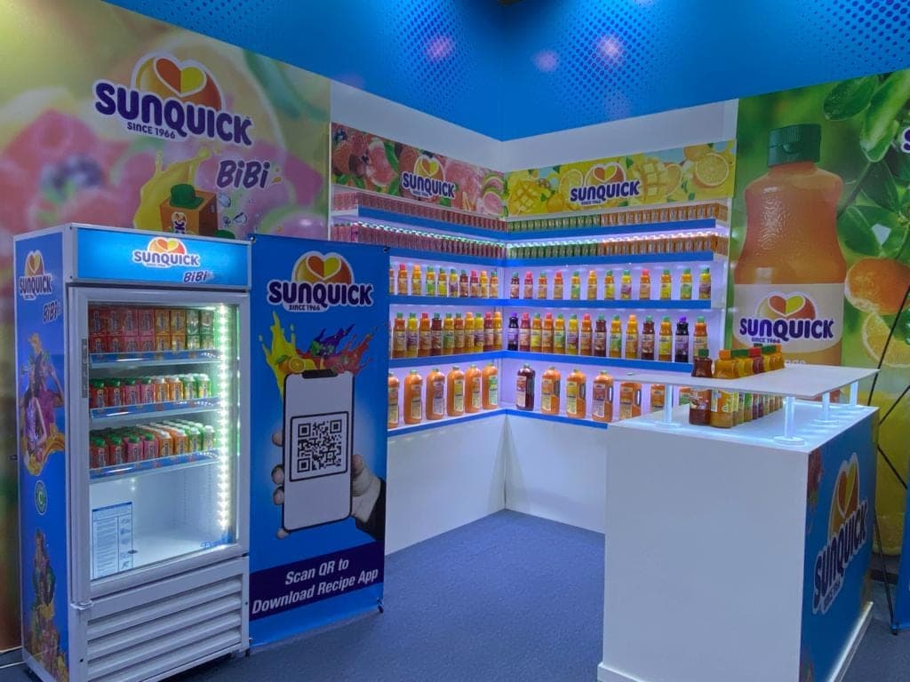 Sunquick product shelving wall and branded cooler inside the stall
