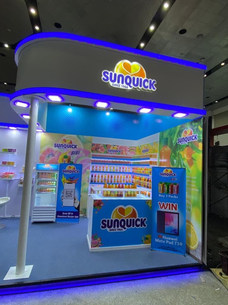 Sunquick stall corner with a lit ceiling cove and product display