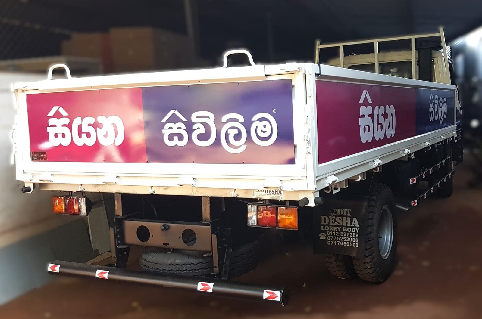 Siyana Sivilima branded flatbed lorry with printed side and tailgate panels